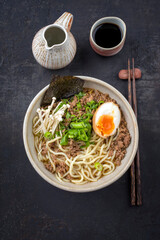 Modern style traditional Japanese ramen mince soup with noudles and egg as top view in a design bowl