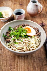 Modern style traditional Japanese ramen mince soup with noudles and egg as close-up in a design bowl
