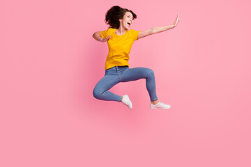 Photo of impressed funny young woman dressed yellow t-shirt jumping high practicing yoga isolated pink color background