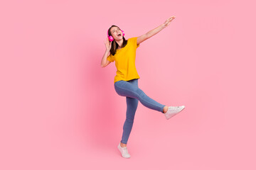 Fototapeta na wymiar Photo of funky adorable young woman dressed yellow t-shirt walking dancing singing empty space isolated pink color background
