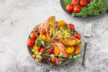 Omelet with stewed vegetables and salmon, tomatoes with onions, broccoli and red fish with pea microgreens, delicious hearty breakfast