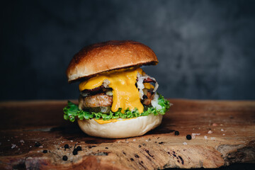 Chicken burger with sauerkraut, pickles and mustard on wooden board