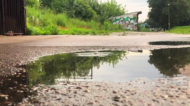 View of water droplets falling down after a rain on the road surface.