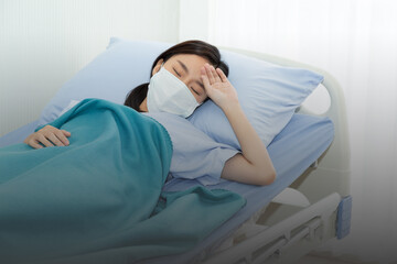 Close up upset Asian patient woman wearing safety mask from coronavirus at hospital or quarantine home alone lying in bed waiting for doctor. Covid-19 outbreak around the world.