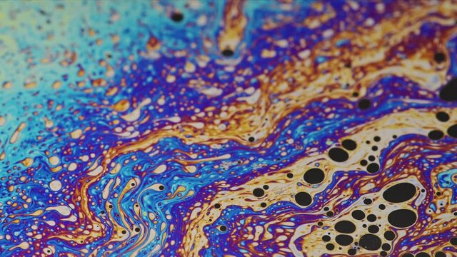 swirling, abstract interference pattern on a soap surface