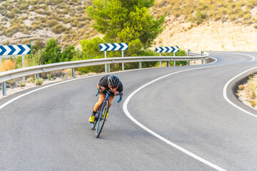 Professional cyclist performing downhill at full speed on mountain biker road