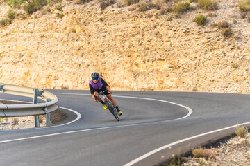 Obraz premium Professional cyclist performing downhill at full speed on mountain biker road