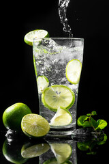 Cold lemonade with splash for summer refreshing drink isolated on a black background.