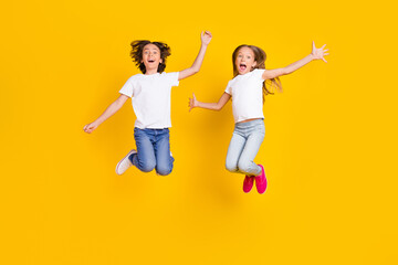 Full length body size view of two nice crazy cheerful carefree kids jumping having fun fooling...