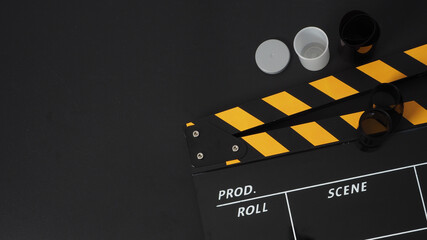 35mm color print film and Clapper board or movie slate on black background. It use in movie and...