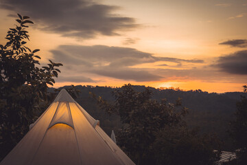 sunrise in morning with camping tent on mountain