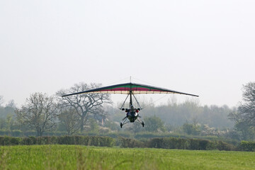Obraz na płótnie Canvas Ultralight airplane taking off from a grass airfield 