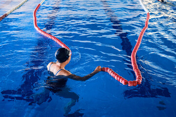 Anonymous woman in pool with lane dividers