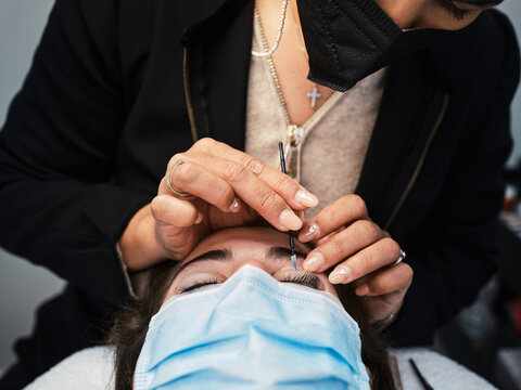 Beauty specialist doing eyelash lamination to client