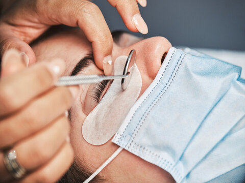 Beautician With Mirror Treating Eyelashes Of Woman