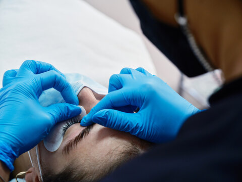Woman getting eyelash lifting procedure in salon