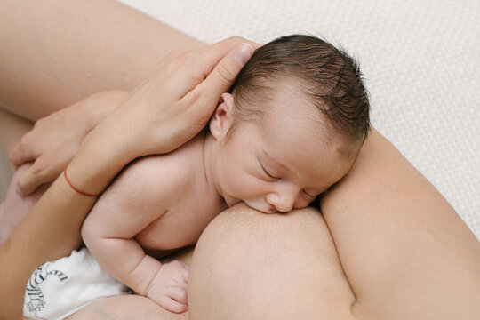 Anonymous mother breastfeeding baby in room at home