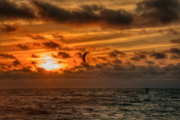 Windsurfer Riding the Waves During Orange Sunset off the Beach