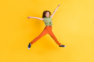 Fototapeta na wymiar Full length body size photo little girl jumping high cheerful happy isolated vibrant yellow color background