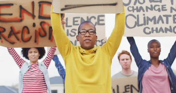 Diverse group of protesters holding cardboard banners and screaming