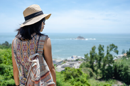 Beautiful Asian girl enjoying the seaside in sunny summer's day
