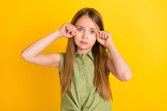 Photo of sad blond small girl cry wear khaki blouse isolated on yellow color background