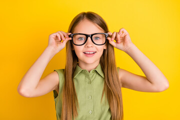Photo of nice blond little girl hold eyewear wear khaki blouse isolated on yellow color background