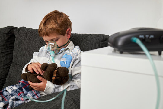 Content Sick Boy In Oxygen Mask Playing With Toy