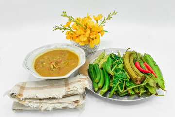 Myanmar or Burmese Traditional Fish Preserve Sauce, Ngapi yay and Fresh Vegetables, chilies , bottle gourd leaves, bitter gourd, flat green peas in steel plate.