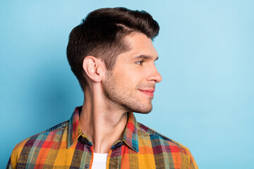 Portrait of attractive cheery well-groomed brunette guy wearing checked shirt looking aside...