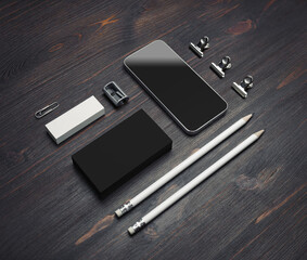Photo of blank smartphone, black business cards, pencils, eraser and sharpener on wood table background. Stationery mock up.