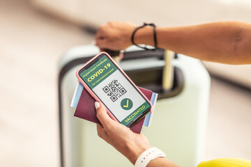 Travelling documents like passport, fly ticket and covid-19 pass with QR code in hands of traveller