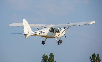 Whiteplane takes off from the airport against the backdrop of a clear sky during the day