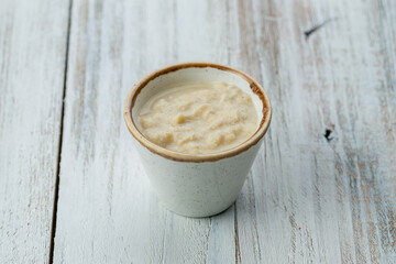 horseradish sauce in a saucepan on white wooden table