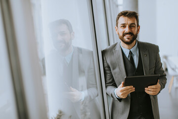 Fototapeta premium Young modern businessman using digital tablet in the office