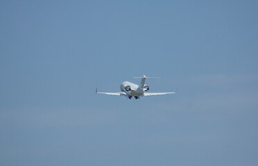 Private white business jet plane takes off from the airport against the backdrop of a clear sky...