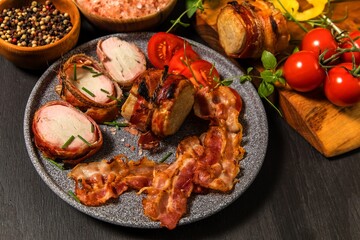 Grilled pork medallions with herbs and spices. Pork tenderloin with bacon. Grilled meat and tomatoes. Summer barbecue. Diet food.
