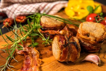 Grilled pork medallions with herbs and spices. Pork tenderloin with bacon. Grilled meat and tomatoes. Summer barbecue. Diet food.