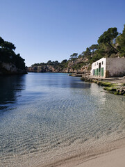 A small hidden cala beach in Mallorca Spain, no people in the morning light, crystal clear mediterranean sea water