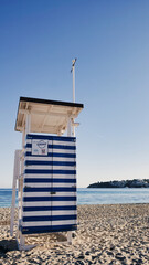 Lifeguard tower house at the beach, walls in white and blue stripes in Majorca, Spain