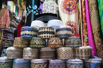 The Kumma is the typical handmade Omani cap, colorful traditional hat in a market souq in Muscat,...