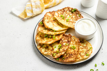 Fluffy zucchini fritters with yogurt sauce. Space for text.