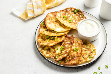 Fluffy zucchini fritters with yogurt sauce. Space for text.