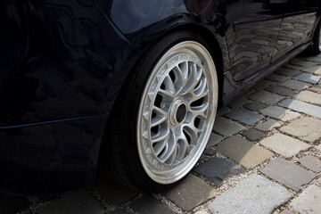 Modern car wheel with a light alloy disc. Low chassis.