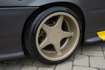 Modern car wheel with a light alloy disc. Low chassis.