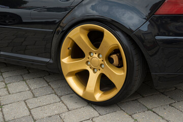 Modern car wheel with a light alloy disc. Low chassis.