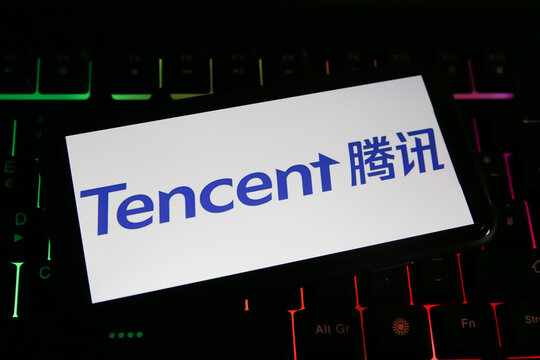 Viersen, Germany - June 1. 2021: Closeup of mobile phone screen with logo lettering of chinese tencent company on computer keyboard