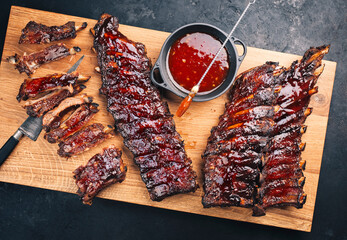 Barbecue pork spare loin ribs St Louis cut with hot honey chili marinade served as top view on a wooden board