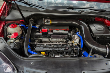 Fototapeta na wymiar Open car hood. Engine and other motor parts