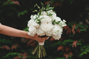 White bridal bouquet of peonies and roses. Scenery for the wedding.